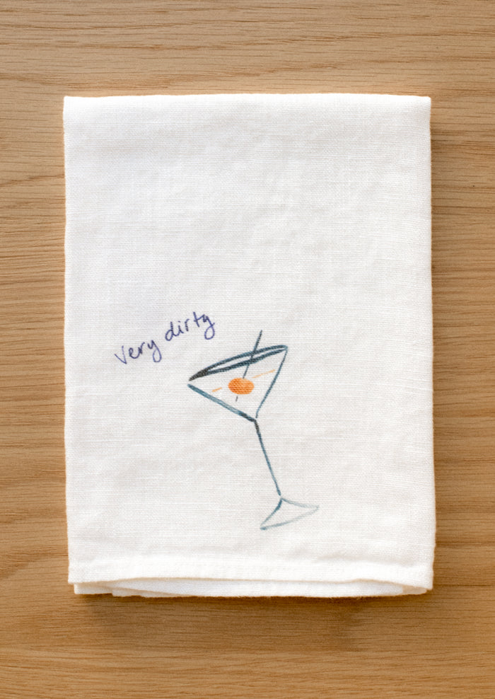 A white linen napkin with graphic detail of dirty martini.