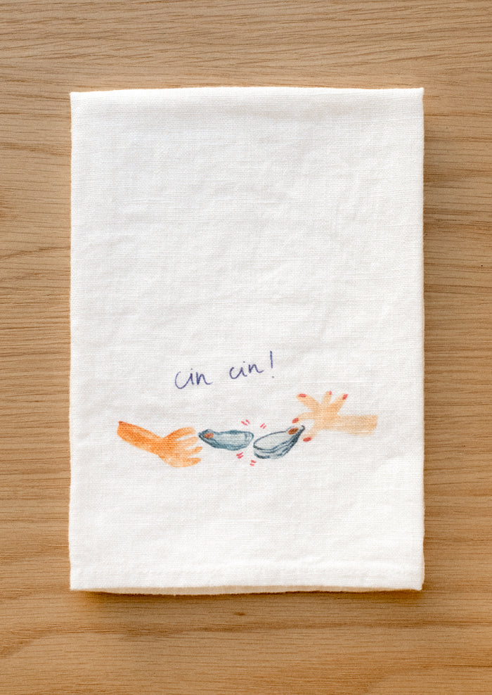 A white linen napkin with graphic detail of oyster cheers Cin Cin.