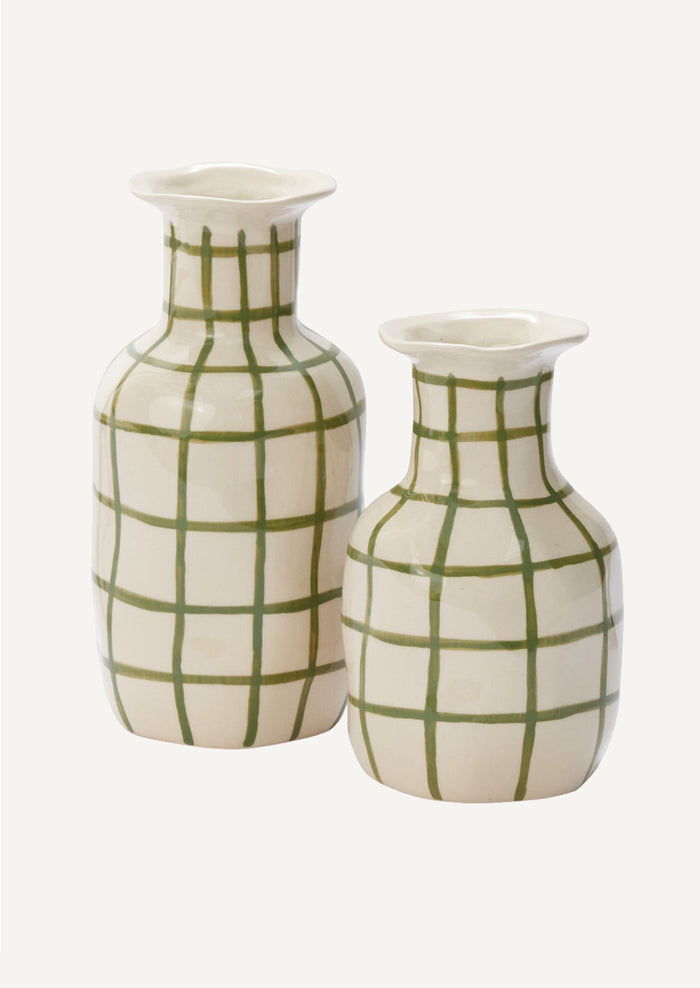 A ceramic vase in white with green grid pattern.