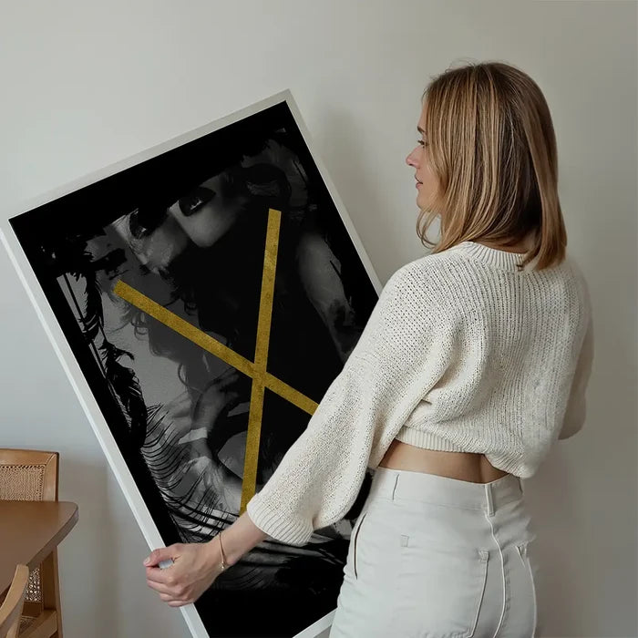 Woman holding "Girl In Window Gold Print" featuring an abstract female form and gold graphic elements.