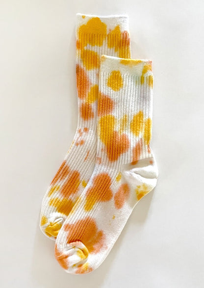 A pair of tie dye socks in yellow and orange color.