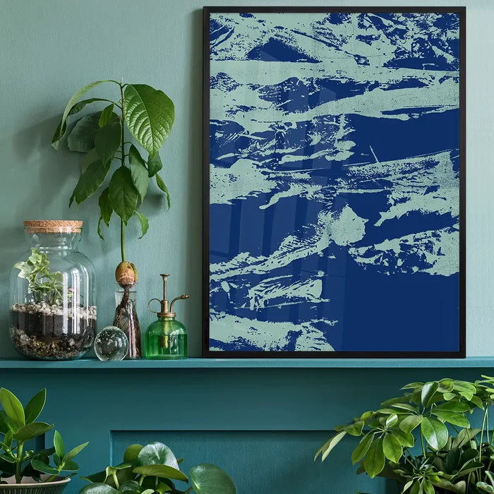 Inky blue graffiti print on thick art paper, framed and displayed on a teal shelf with plants.