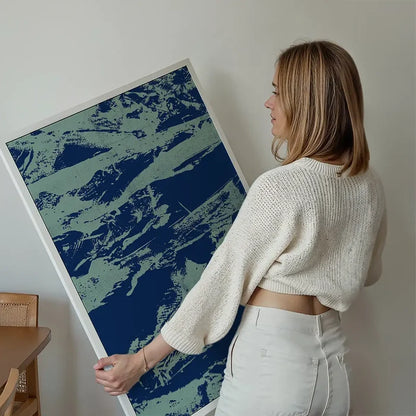 Woman holding a framed inky blue graffiti print on thick art paper, featuring urban style.
