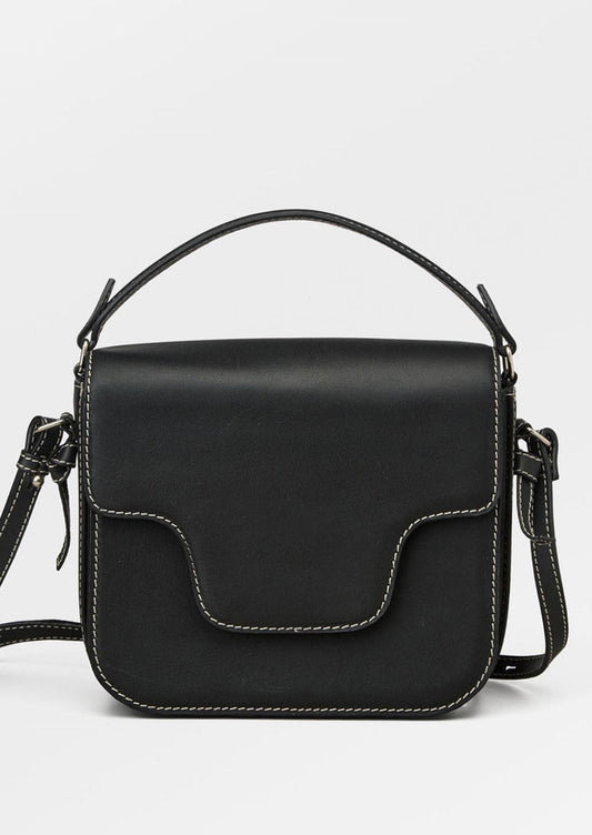 A leather handbag in black with white contrast stitching and flap front design.