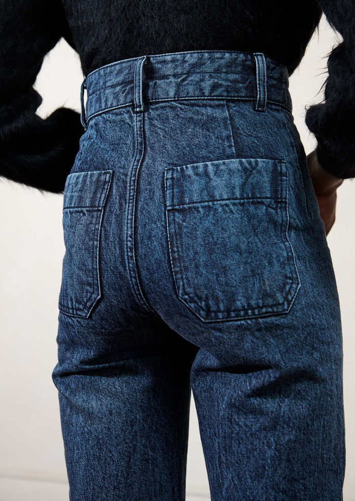 Woman wearing blue jeans, seen from the back.