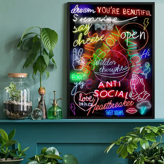 Vibrant neon sign mashup print in a black frame, featuring colorful text and symbols on a dark background.