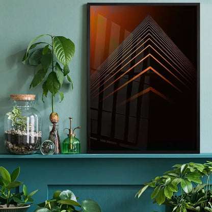 Black framed geometric print with abstract orange pyramid shapes on a dark background, displayed on a teal shelf.
