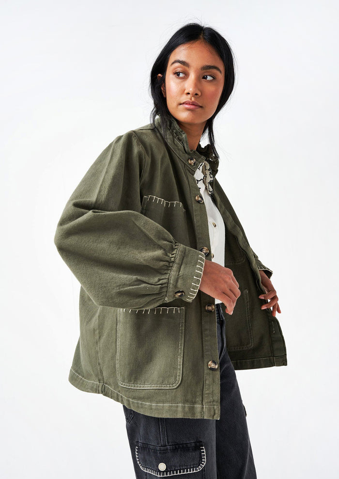 Woman wearing a khaki green cotton jacket.