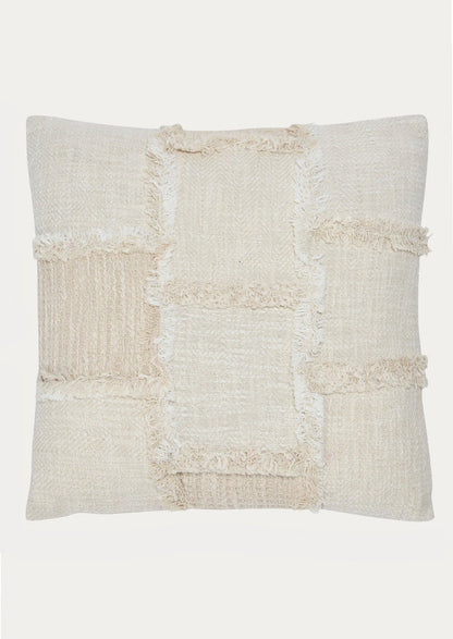 A throw pillow in natural cotton with patchwork detailing in different textures.