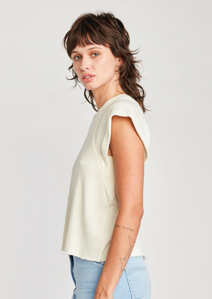 A woman wearing a raglan short sleeve sweatshirt in cream.